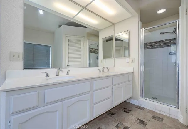 a bathroom with double sink and a mirror