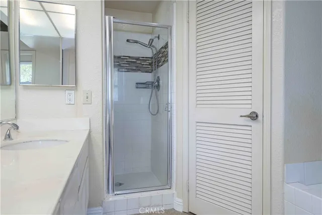 a bathroom with a granite countertop shower a sink and a bathtub