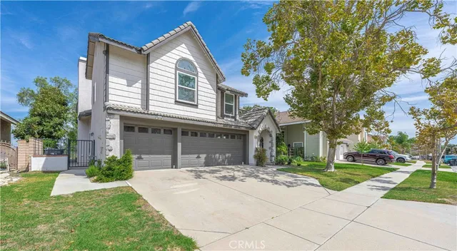 a front view of a house with a yard and potted plants