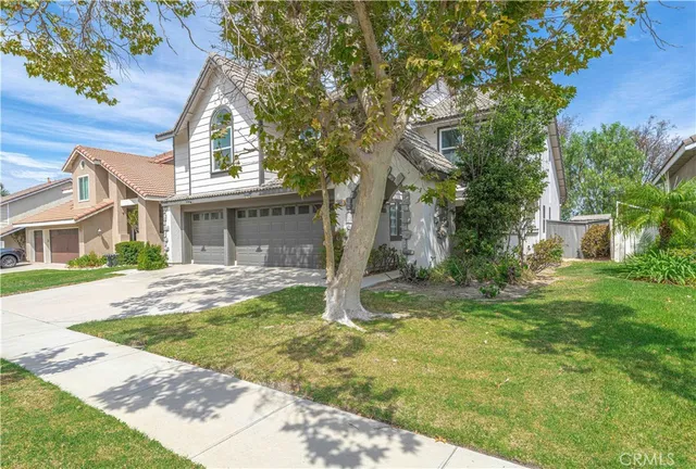 a view of a house with backyard and a tree