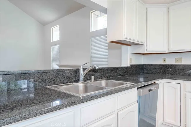 a kitchen with granite countertop a sink and cabinets