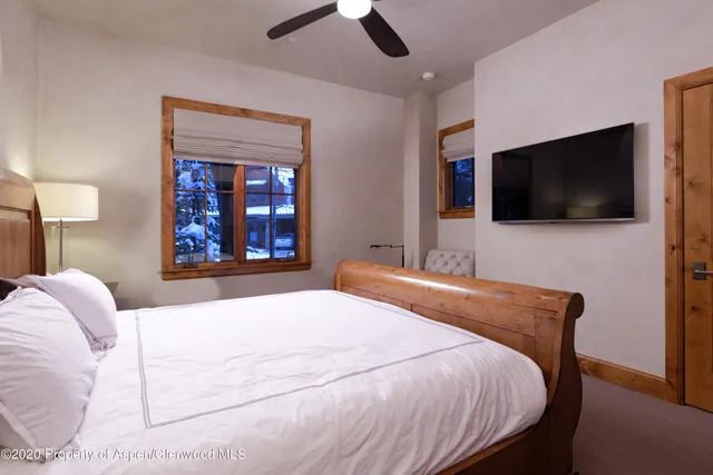 a bedroom with a large bed and a flat screen tv