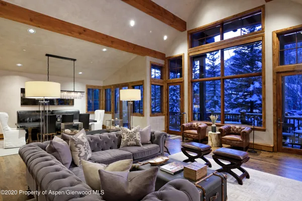 a living room with furniture a large window and gym equipment