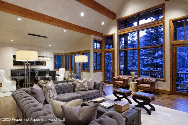 a living room with furniture a large window and gym equipment