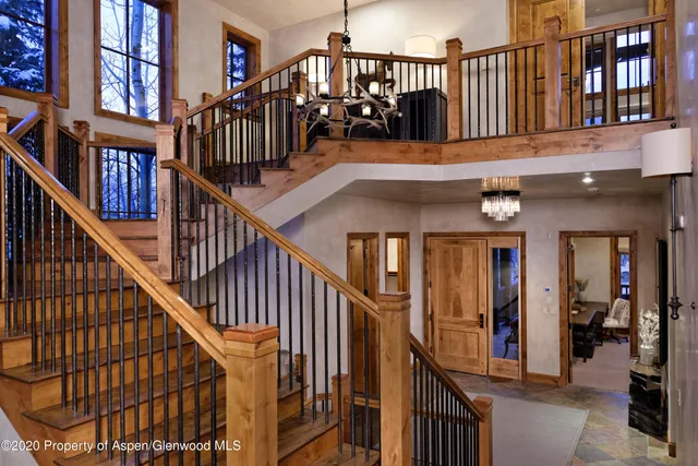 a view of staircase with lots of frames on wall and a window