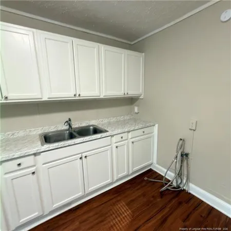 a kitchen with sink cabinets and wooden floor