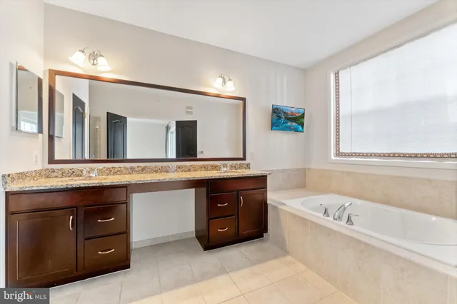 a bath room with a sink and a large mirror