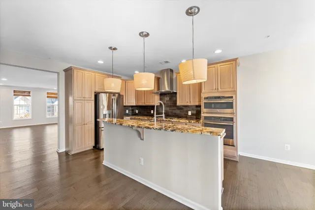 a kitchen with stainless steel appliances and a wooden floor