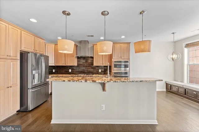 a kitchen with stainless steel appliances granite countertop a refrigerator a oven a sink and a stove