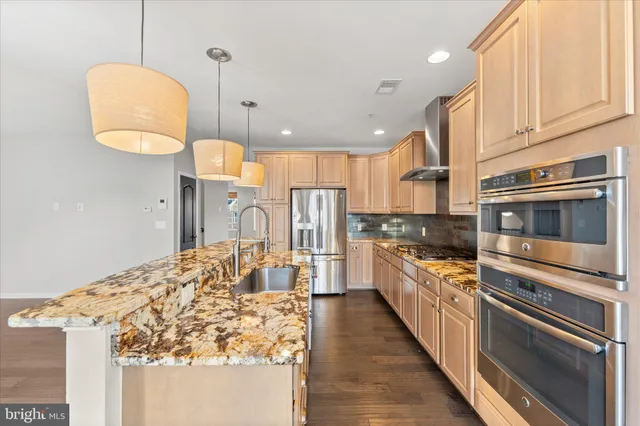 a kitchen with stainless steel appliances granite countertop a sink and a stove