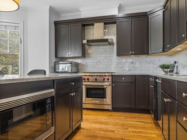 a kitchen with stainless steel appliances granite countertop a stove a sink and a microwave
