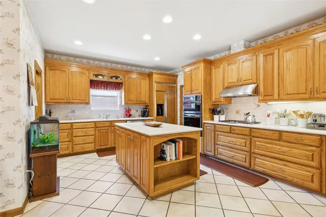 a kitchen with stainless steel appliances granite countertop a stove a sink and a refrigerator