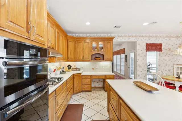 a kitchen with stainless steel appliances a sink stove and cabinets