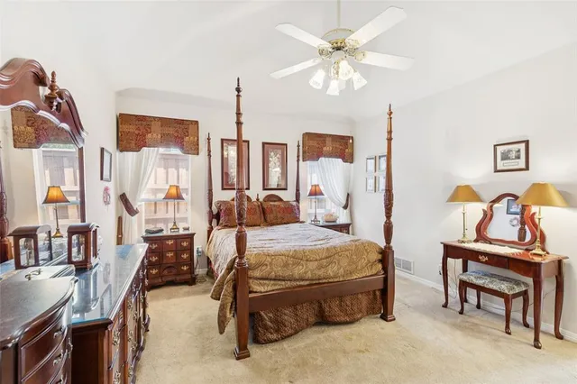 a spacious bedroom with a bed and dresser with mirror