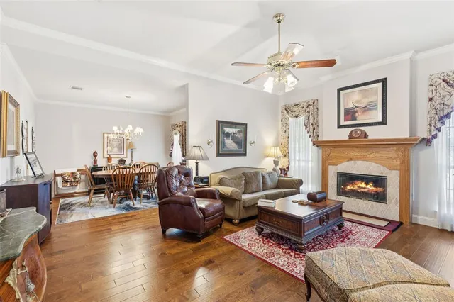 a living room with furniture a fireplace and a chandelier