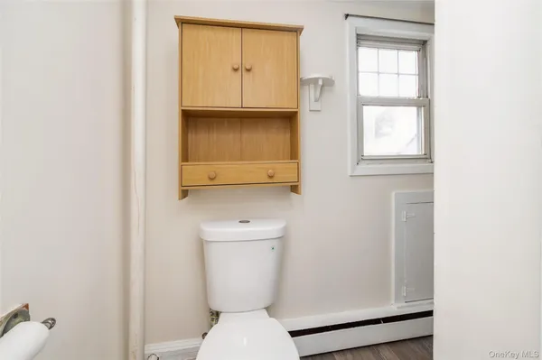 a bathroom with a toilet a sink and a window