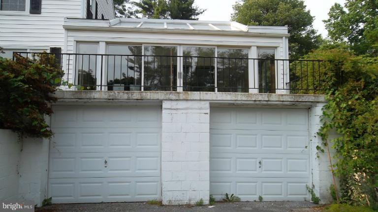 6301 Rt 32 Es Guilford Road Clarksville, MD 21029 - Photo 21 of 28 a view of a house with a large window and potted plants