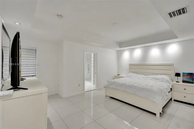 a bedroom with a bed and a flat screen tv