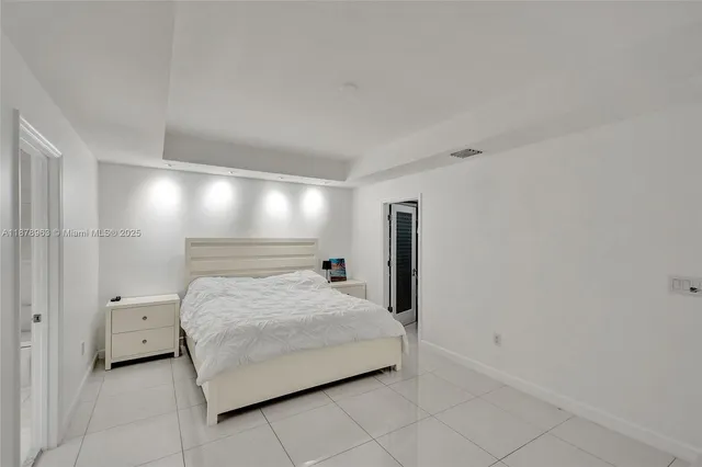 a bedroom with a bed and a night stand