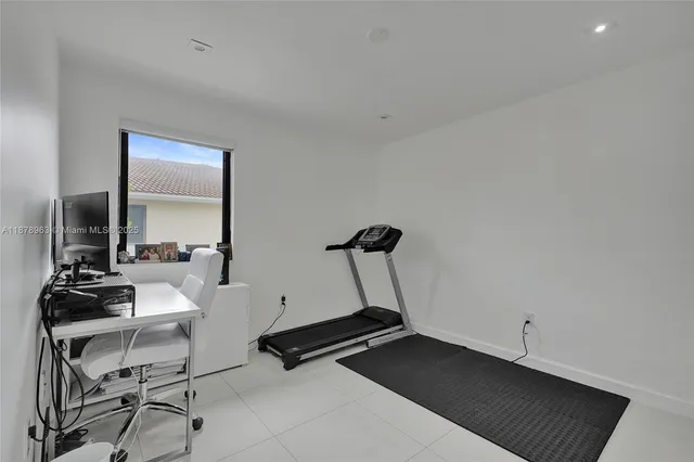 a room with gym equipment and a view of living room