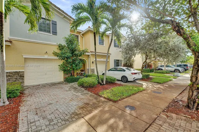 a view of a house with a large tree and plants