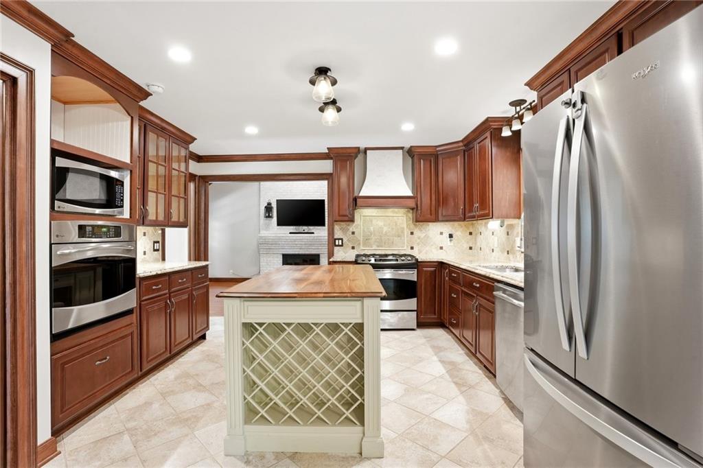210 Woodrill Way Atlanta, GA 30350 - Photo 11 of 34 a large kitchen with stainless steel appliances granite countertop a refrigerator oven a sink dishwasher and white cabinets with wooden floor