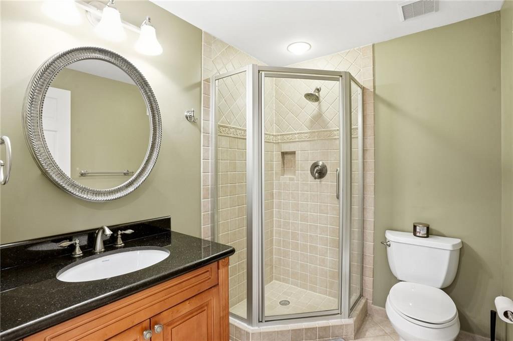 210 Woodrill Way Atlanta, GA 30350 - Photo 31 of 34 a bathroom with a granite countertop toilet a sink and a mirror