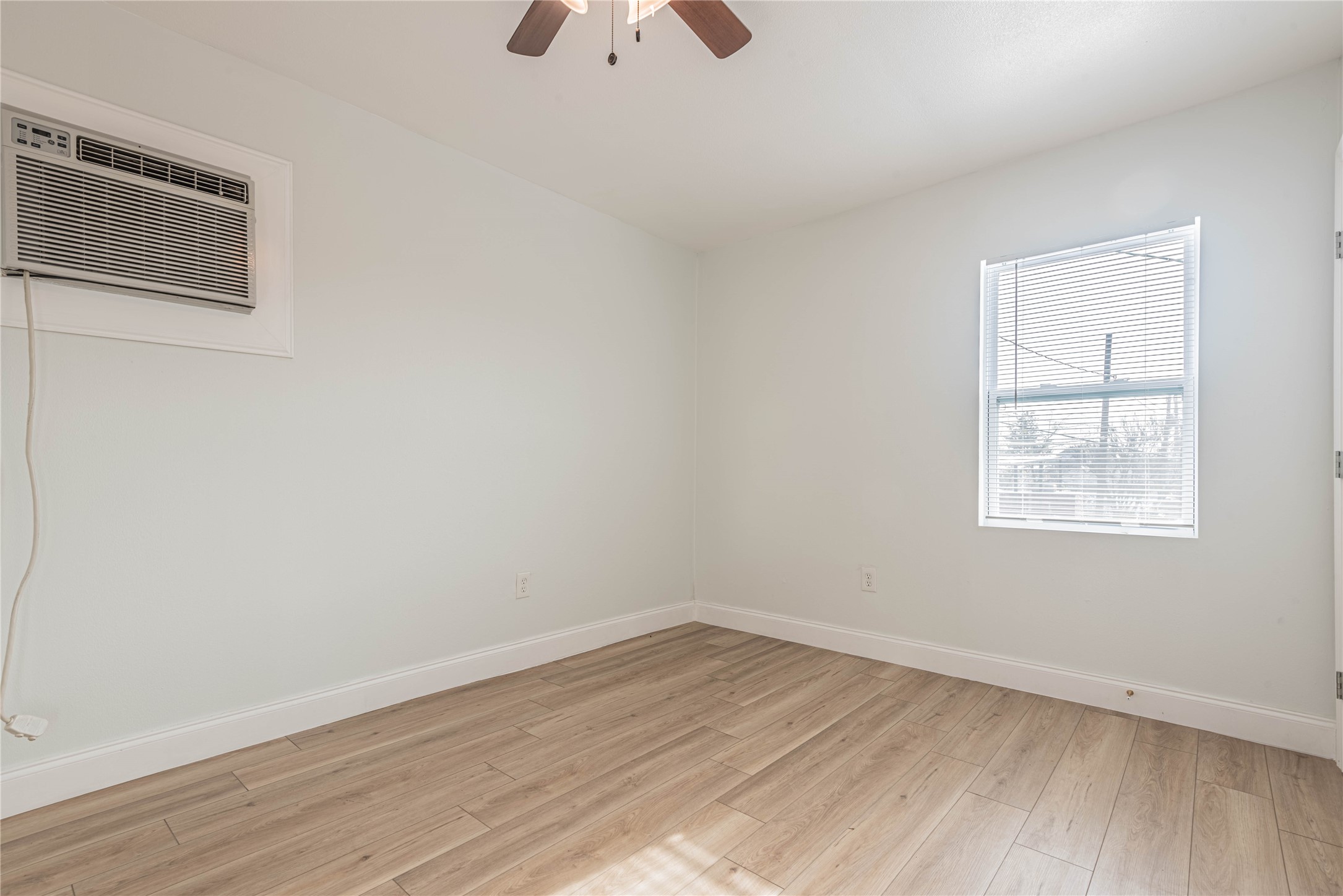 2303 Rosewood Street, Unit 6 Houston, TX 77004 - Photo 11 of 15 an empty room with wooden floor and windows