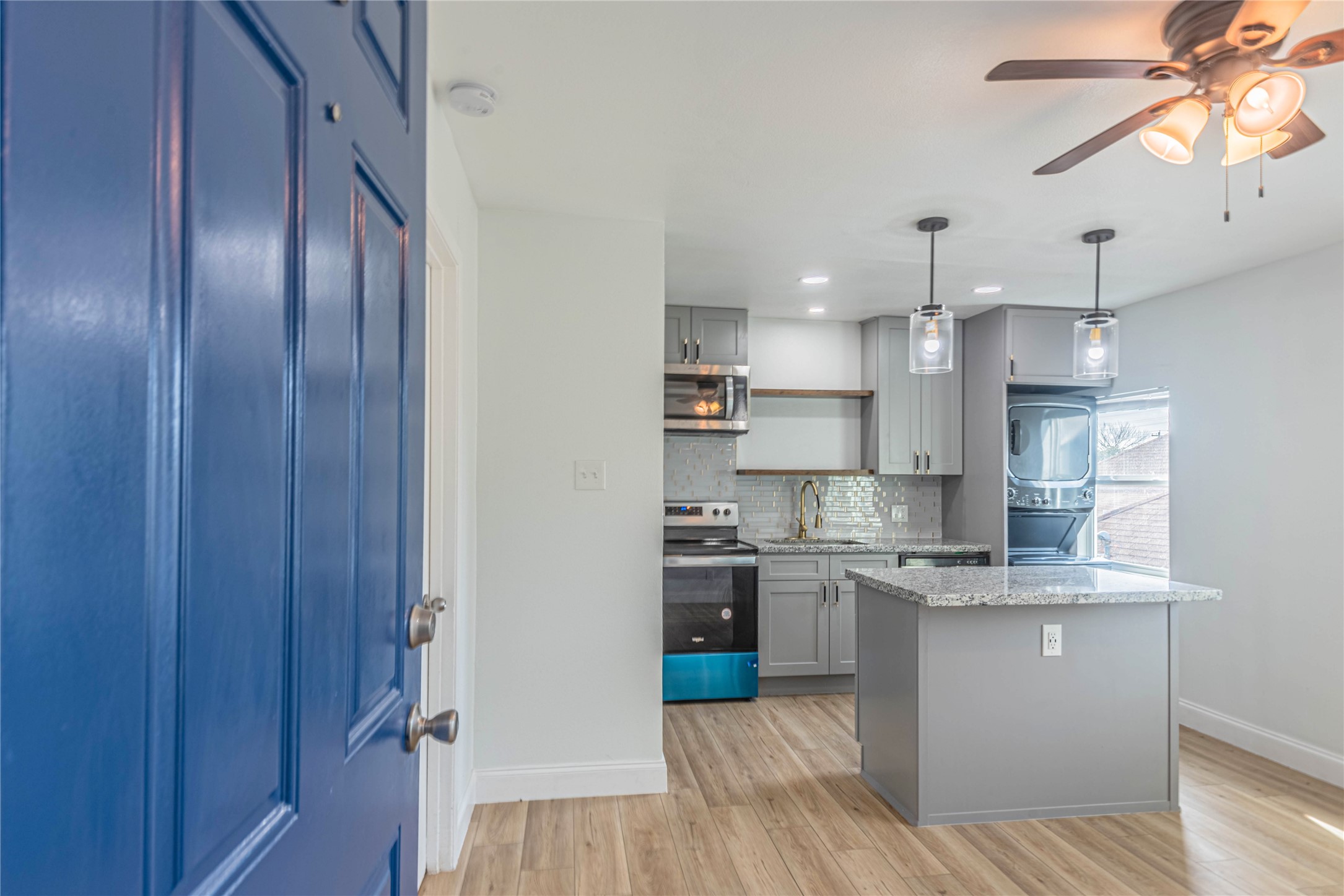 2303 Rosewood Street, Unit 6 Houston, TX 77004 - Photo 2 of 15 a kitchen with stainless steel appliances granite countertop a refrigerator a sink dishwasher a stove and white countertops with wooden floor