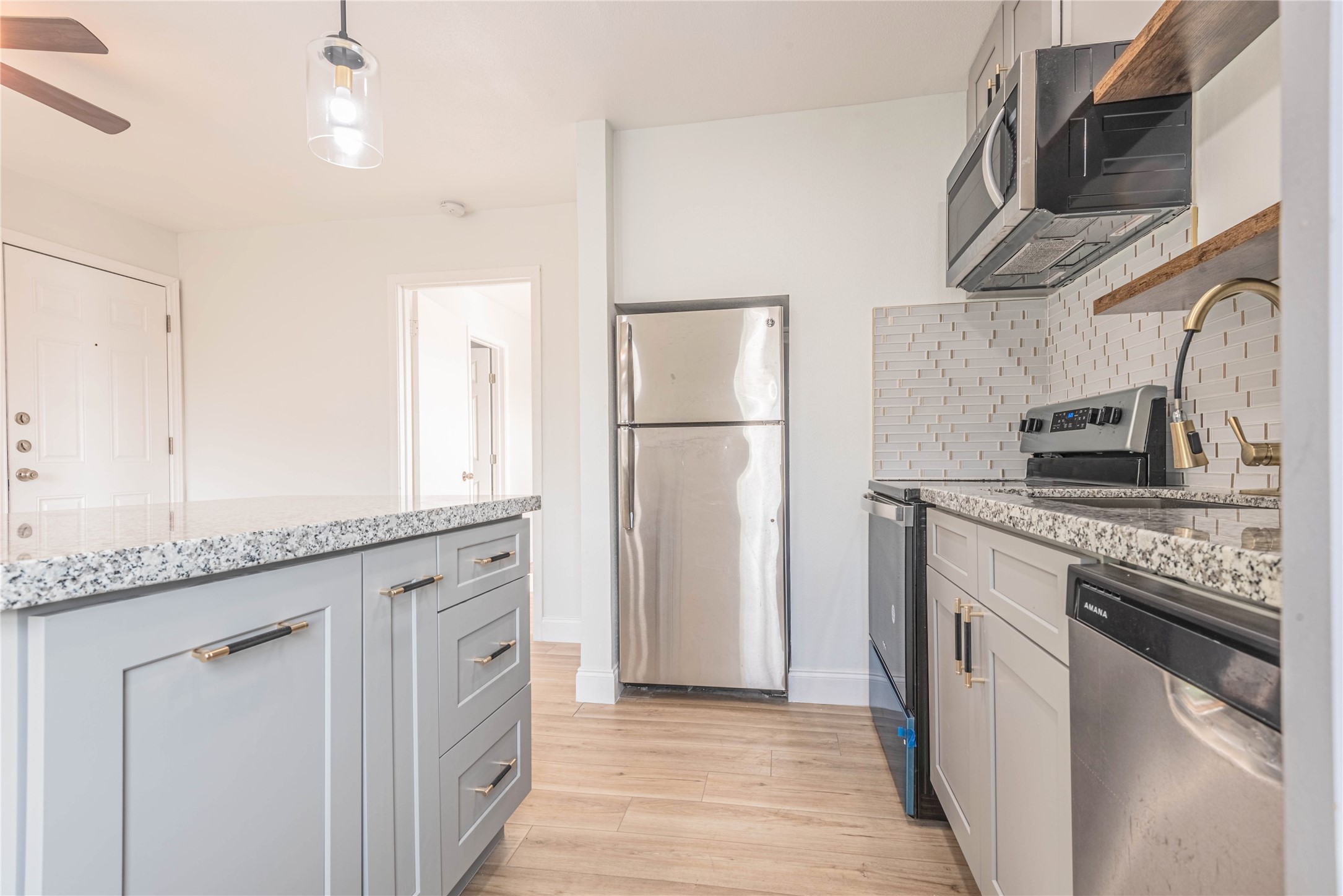 2303 Rosewood Street, Unit 6 Houston, TX 77004 - Photo 7 of 15 a kitchen with stainless steel appliances granite countertop a sink and a refrigerator