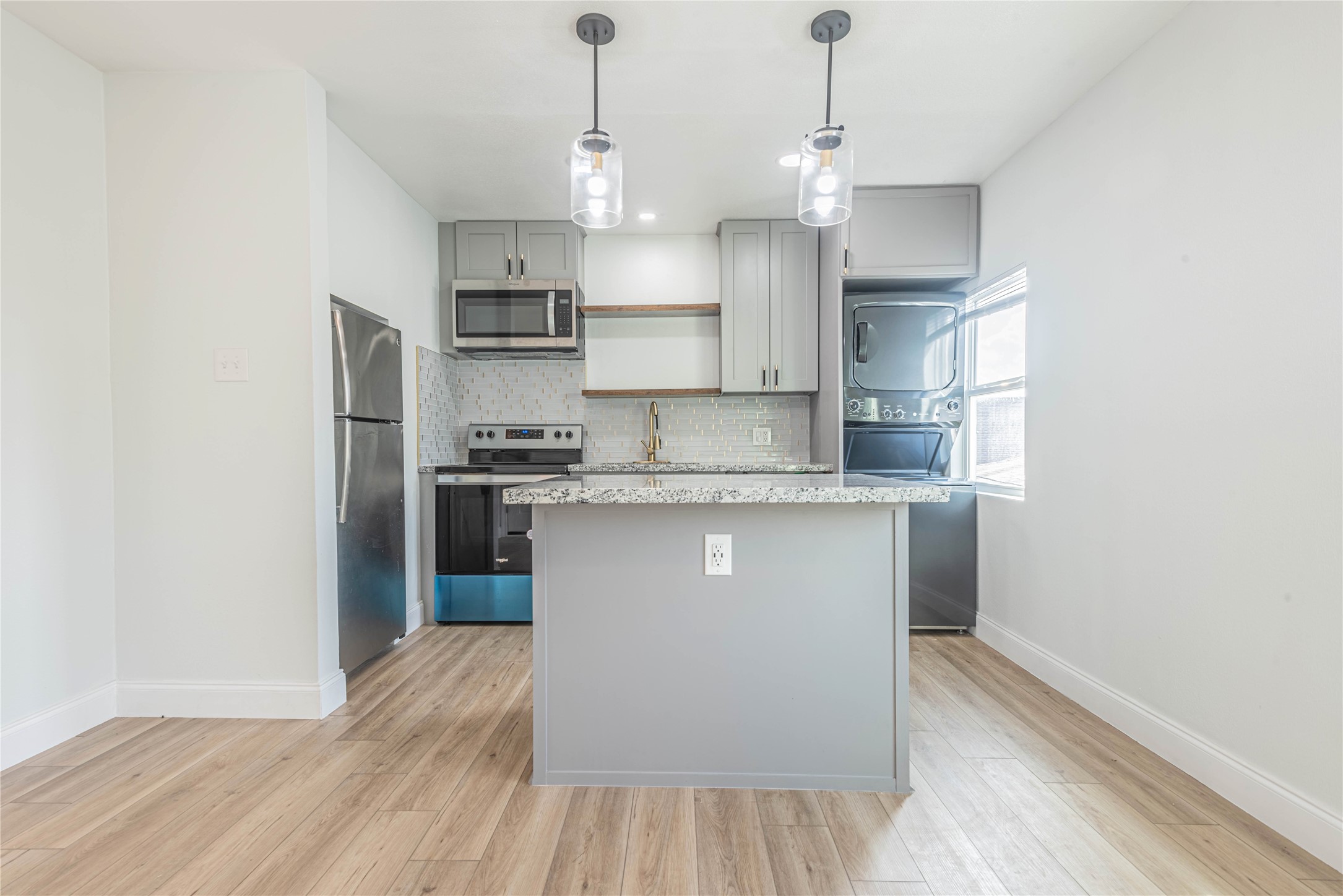 2303 Rosewood Street, Unit 6 Houston, TX 77004 - Photo 8 of 15 a kitchen with kitchen island a counter top space a sink stainless steel appliances and cabinets
