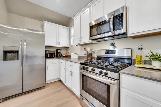 a kitchen with stainless steel appliances granite countertop a stove microwave refrigerator and sink