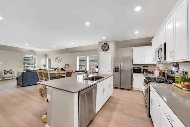 a kitchen with stainless steel appliances granite countertop a sink stove and refrigerator