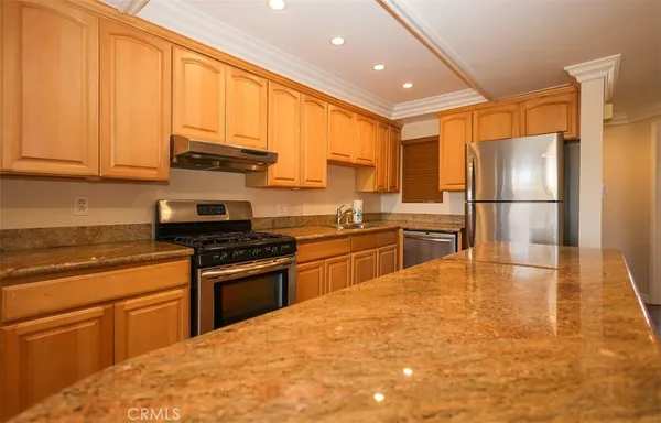 a kitchen with stainless steel appliances granite countertop a stove a sink and a refrigerator