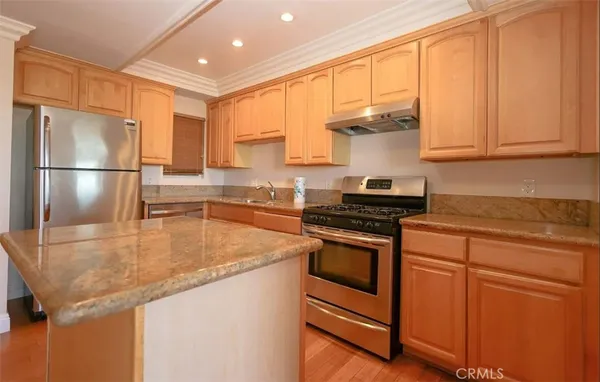 a kitchen with stainless steel appliances granite countertop a sink a stove and a refrigerator