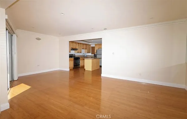 a view of empty room with kitchen and sink