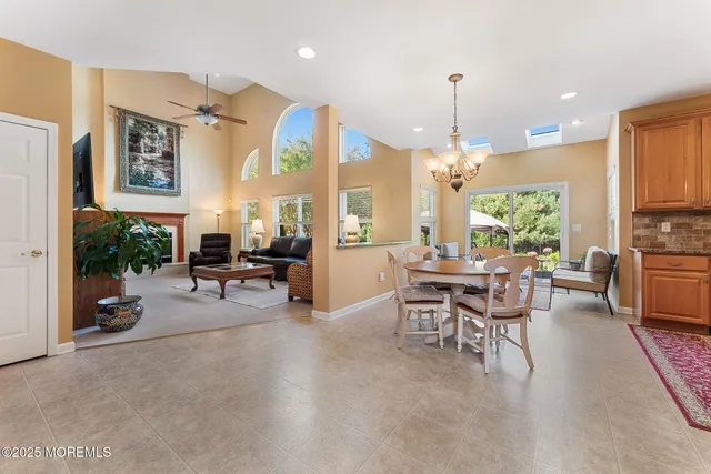 a living room with furniture a fireplace and a dining table with kitchen view