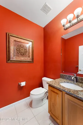 a bathroom with a granite countertop toilet and a sink