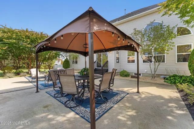 a view of a patio with table and chairs under an umbrella