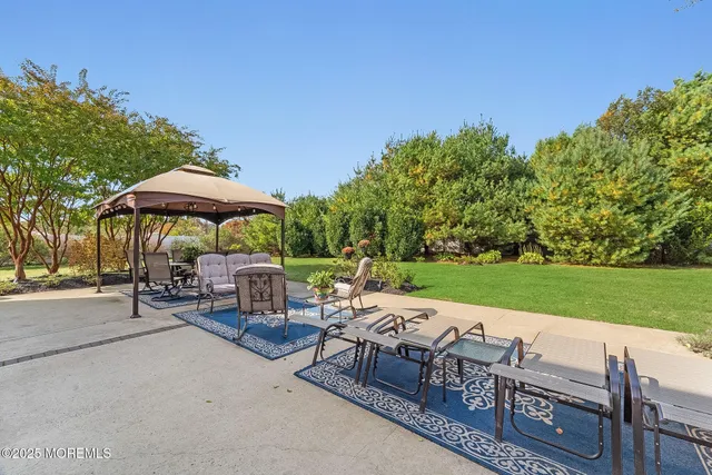 a view of a chairs and table under an umbrella in backyard