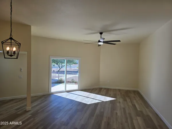 a view of a room with wooden floor and ceiling fan