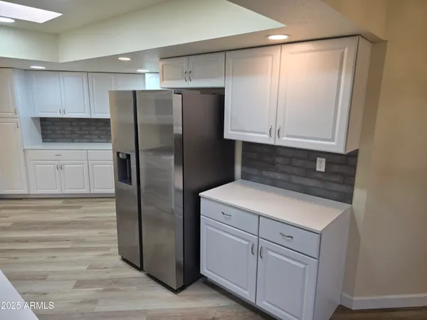 a kitchen with a refrigerator sink and cabinets