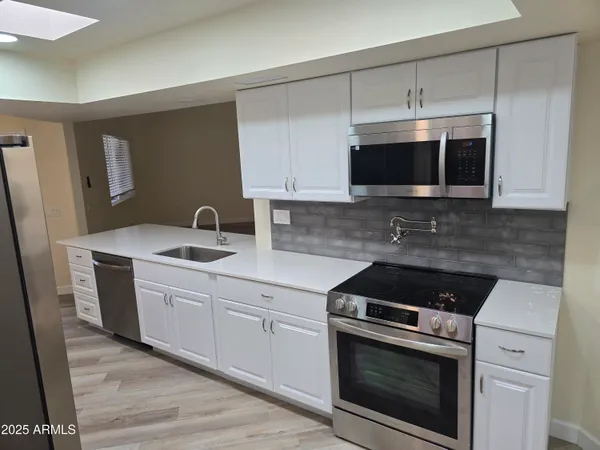 a kitchen with a sink stove and microwave