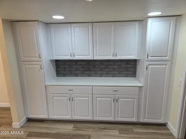 a view of a big room with wooden floor and windows