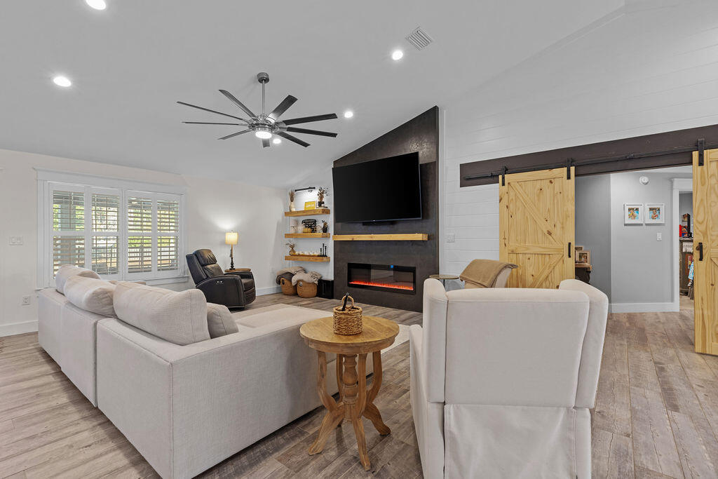 442 Shipwreck Road Santa Rosa Beach, FL 32459 - Photo 31 of 103 a living room with furniture a flat screen tv and a fireplace