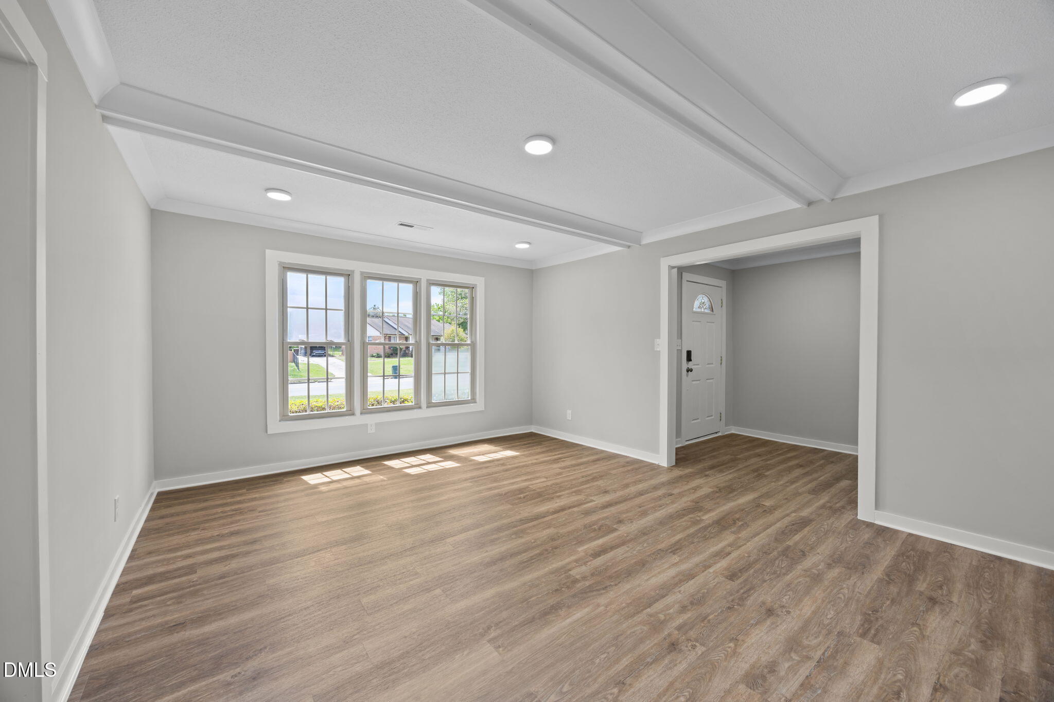 309 Rippling Stream Road Durham, NC 27704 - Photo 11 of 45 a view of an empty room with wooden floor and a window