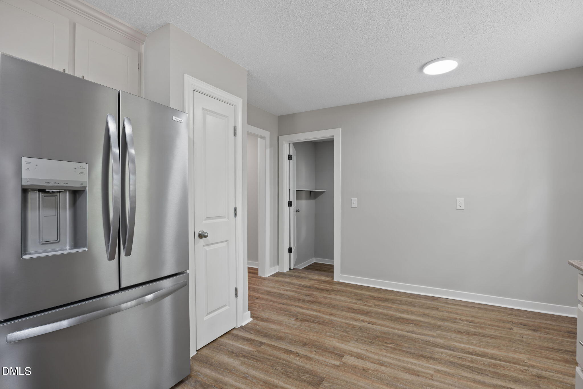 309 Rippling Stream Road Durham, NC 27704 - Photo 17 of 45 a view of a kitchen with a refrigerator and wooden floor
