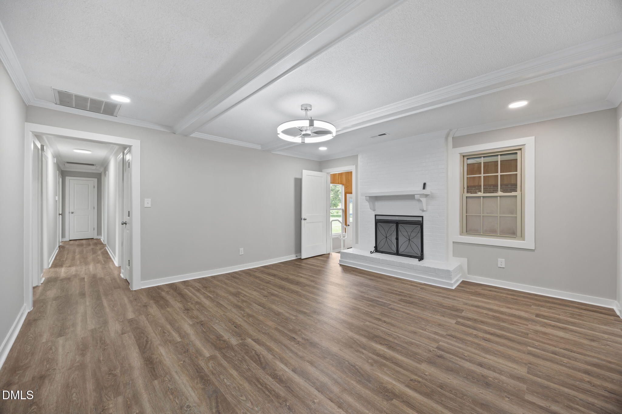 309 Rippling Stream Road Durham, NC 27704 - Photo 19 of 45 a view of an empty room with wooden floor fireplace and a window