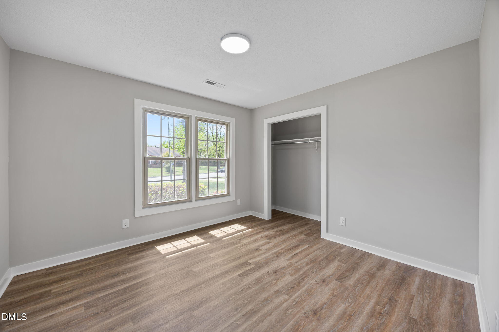 309 Rippling Stream Road Durham, NC 27704 - Photo 28 of 45 a view of an empty room with wooden floor and a window