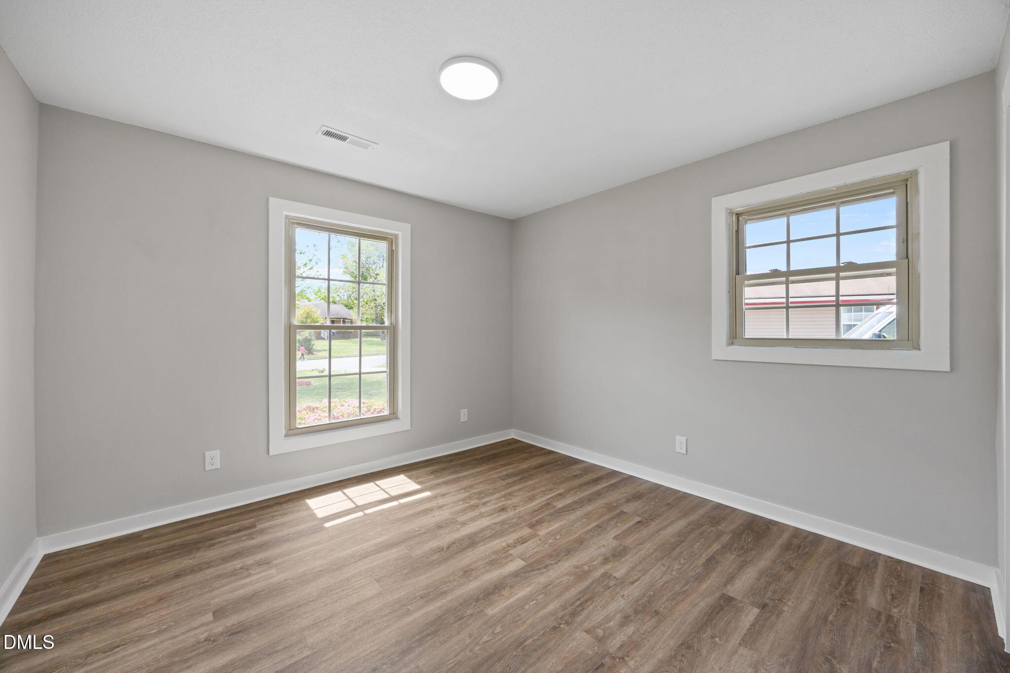 309 Rippling Stream Road Durham, NC 27704 - Photo 32 of 45 an empty room with wooden floor and windows